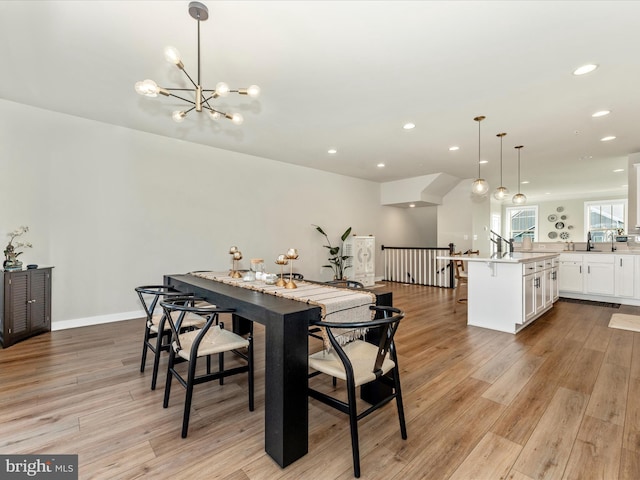 dining space with light wood-type flooring and an inviting chandelier