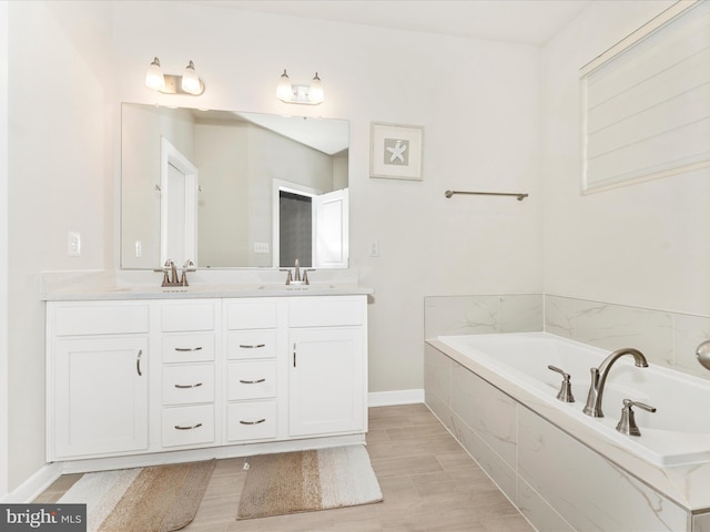 bathroom with vanity and tiled tub