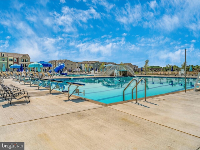 view of swimming pool featuring a patio and a water slide