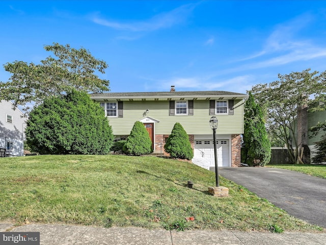 split foyer home with a garage and a front lawn