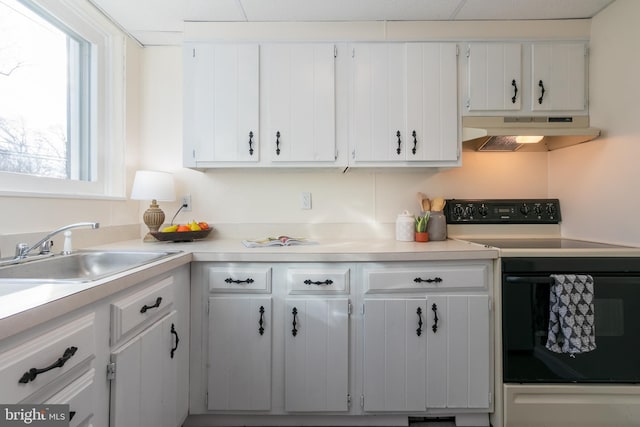 kitchen featuring electric range, sink, white cabinets, and extractor fan