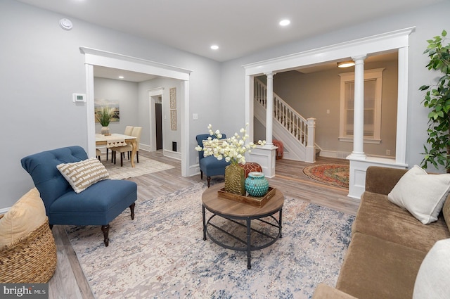 living room with decorative columns and light hardwood / wood-style floors