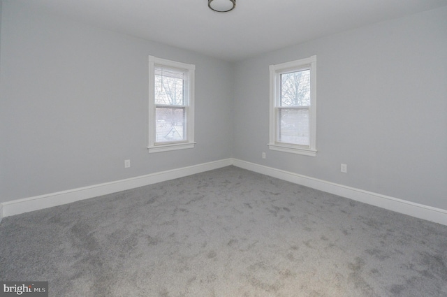 spare room with plenty of natural light and light colored carpet