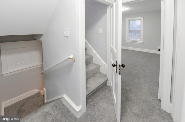 staircase featuring carpet floors and lofted ceiling