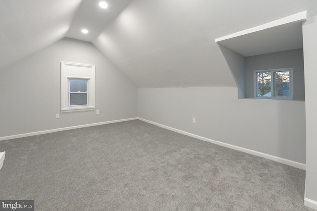 additional living space featuring carpet floors and vaulted ceiling