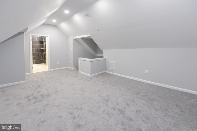 additional living space with carpet flooring and lofted ceiling