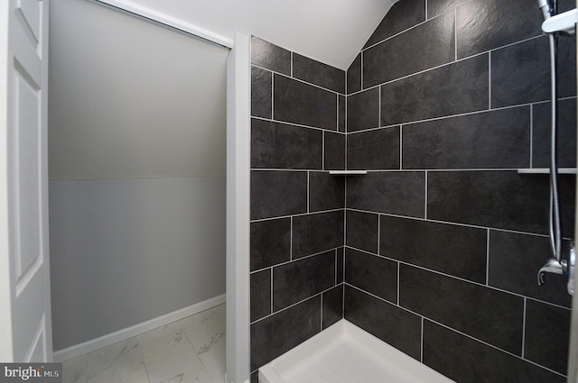 bathroom with a shower and lofted ceiling