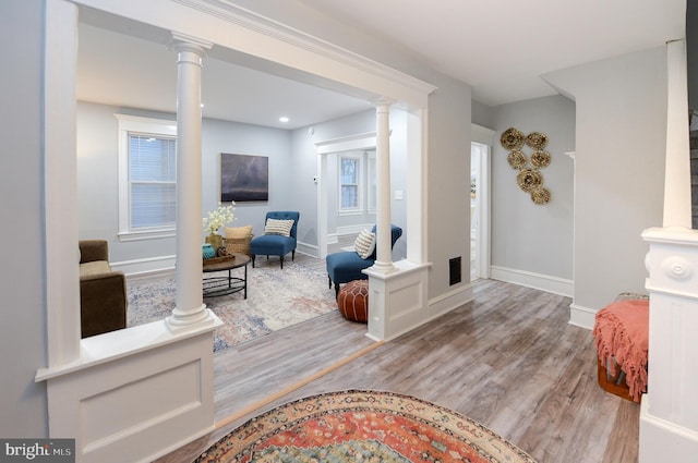 interior space featuring light hardwood / wood-style flooring and ornate columns