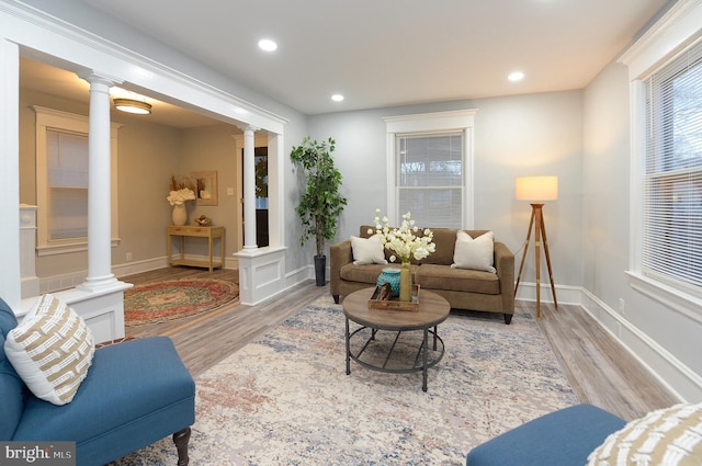 living room featuring ornate columns and light hardwood / wood-style flooring