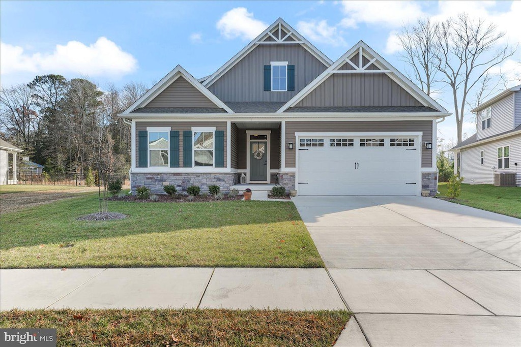 craftsman inspired home featuring a garage, a front yard, and central AC unit