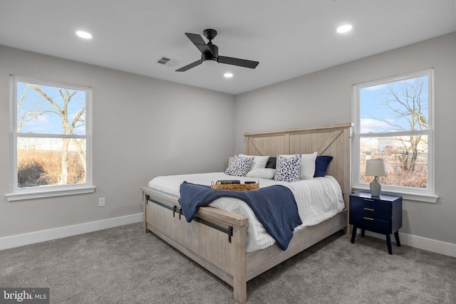 bedroom with light carpet, multiple windows, and ceiling fan