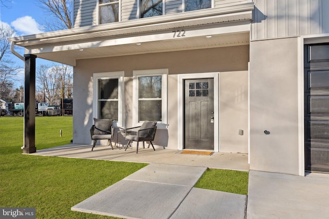 entrance to property featuring a lawn