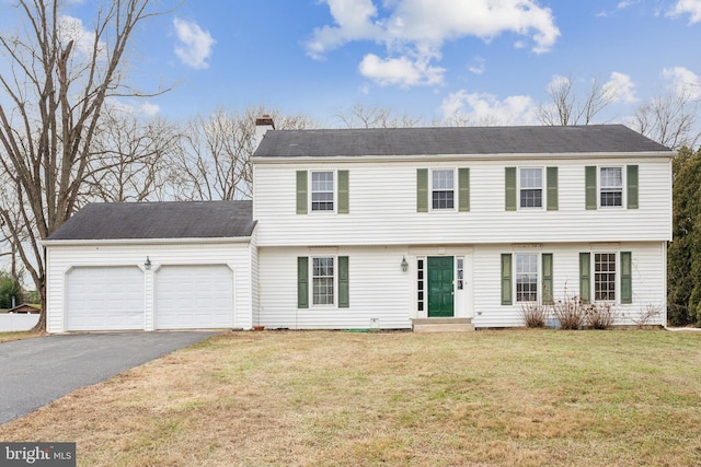 colonial home with a front yard and a garage