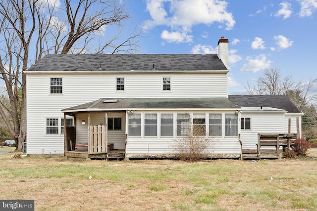 rear view of house with a sunroom and a yard