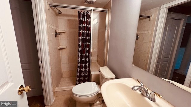 bathroom featuring a shower with shower curtain, tile patterned flooring, and toilet