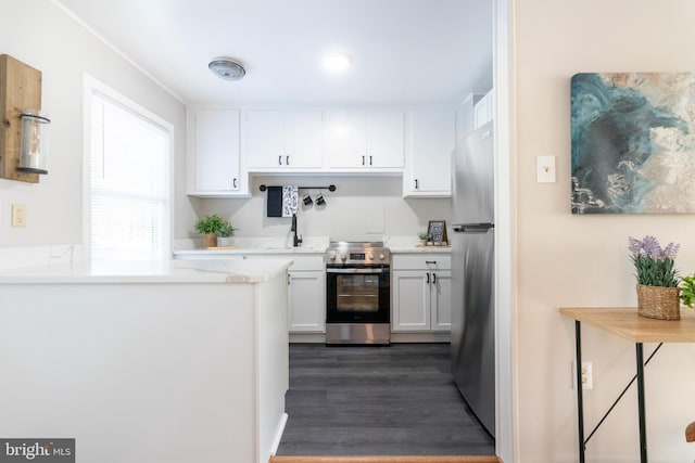 kitchen with stainless steel appliances, white cabinetry, and dark hardwood / wood-style floors