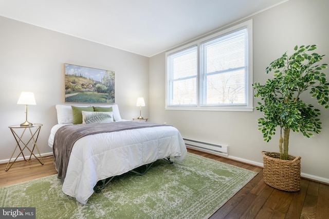 bedroom with baseboard heating and wood-type flooring