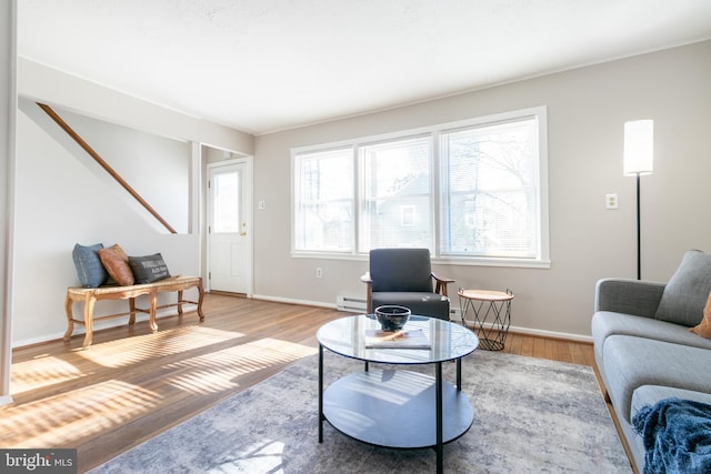 living room featuring a baseboard heating unit and light hardwood / wood-style floors