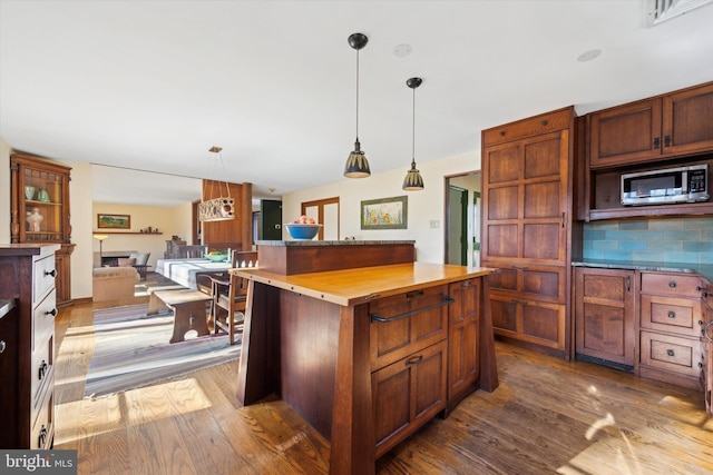 kitchen with backsplash, wooden counters, a kitchen island, and light hardwood / wood-style floors