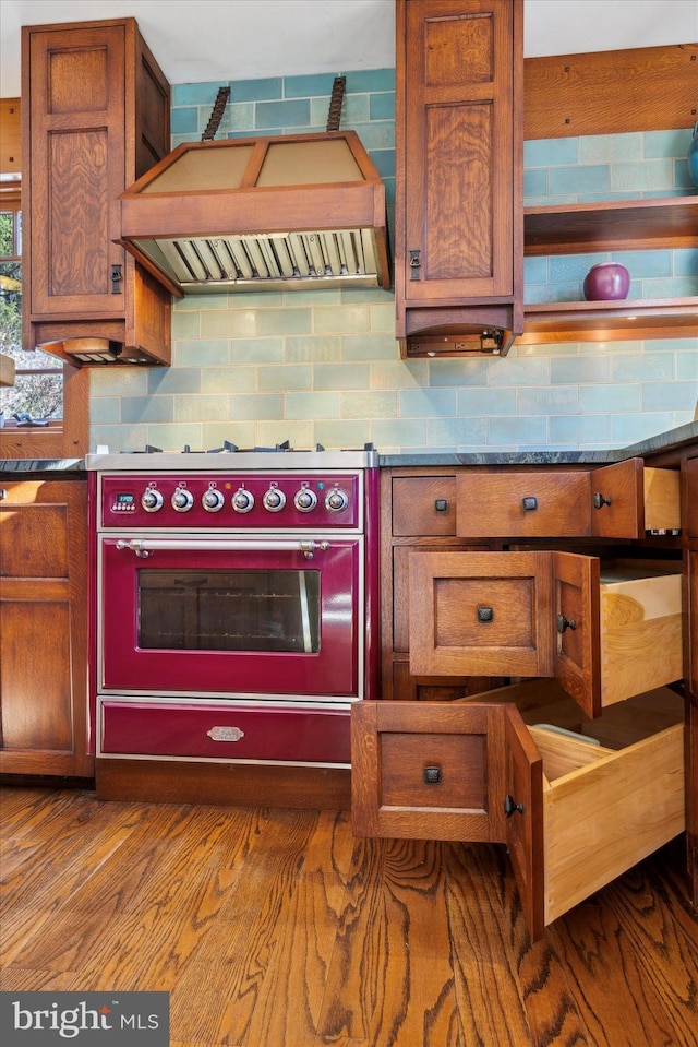 kitchen with backsplash, wall oven, premium range hood, and light hardwood / wood-style flooring