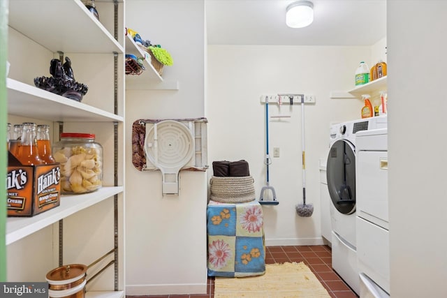 washroom featuring washer and clothes dryer and dark tile patterned flooring