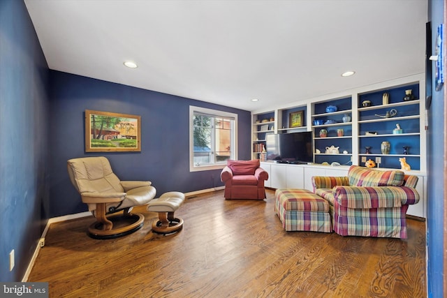 sitting room featuring hardwood / wood-style flooring and built in features