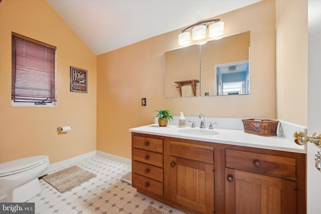 bathroom featuring vanity, vaulted ceiling, and toilet