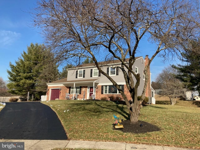 view of front of property featuring a front lawn, covered porch, and a garage