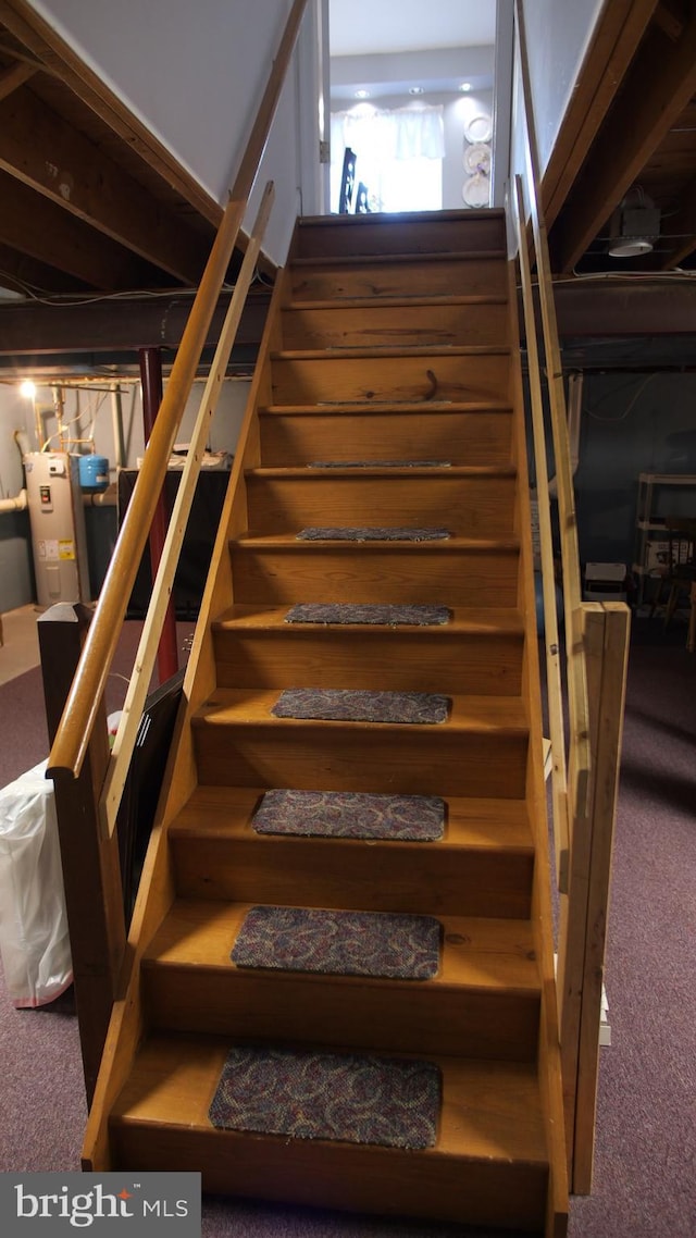 staircase featuring carpet and electric water heater