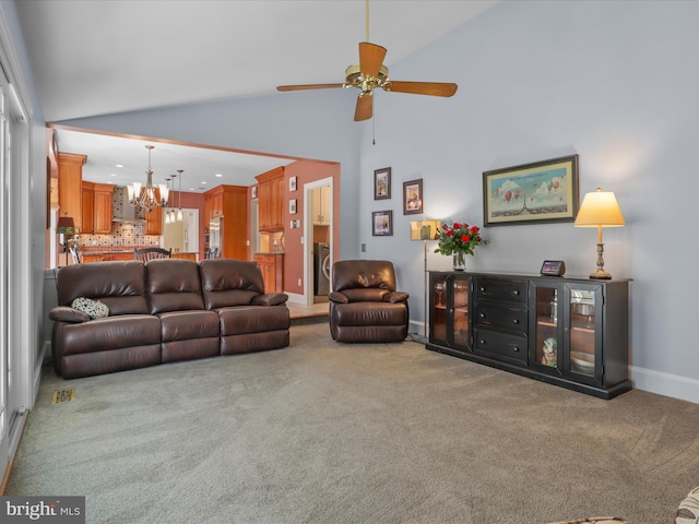 carpeted living room featuring washer / clothes dryer, visible vents, high vaulted ceiling, baseboards, and ceiling fan with notable chandelier