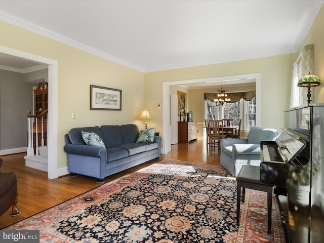 living area with ornamental molding, stairway, and wood finished floors