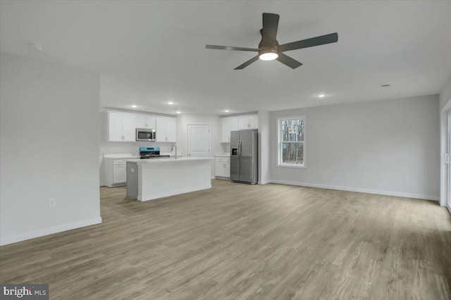 unfurnished living room featuring ceiling fan, light hardwood / wood-style flooring, and sink