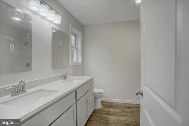 bathroom with hardwood / wood-style floors, vanity, and toilet