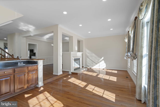 kitchen with crown molding, sink, dark wood-type flooring, and a fireplace