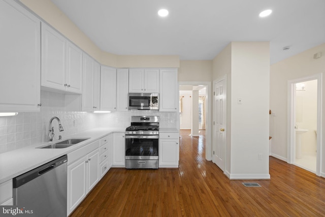 kitchen with stainless steel appliances, white cabinetry, and sink