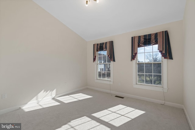 unfurnished room with light colored carpet and lofted ceiling