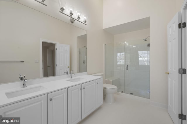 bathroom featuring tile patterned flooring, vanity, toilet, and a shower with shower door