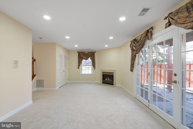 unfurnished living room featuring light carpet