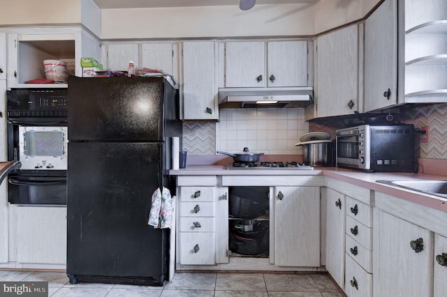 kitchen with tasteful backsplash, light tile patterned floors, and black appliances