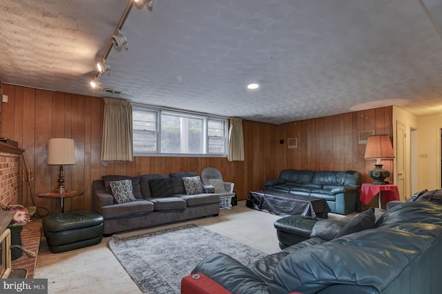 living room featuring light carpet, a textured ceiling, and wood walls