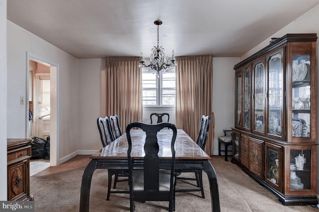 carpeted dining room featuring an inviting chandelier