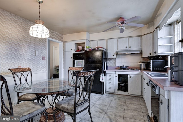 kitchen featuring tasteful backsplash, hanging light fixtures, light tile patterned floors, ceiling fan, and black appliances