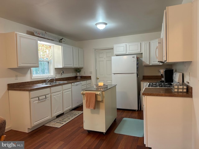 kitchen featuring a center island, sink, dark wood-type flooring, white appliances, and white cabinets