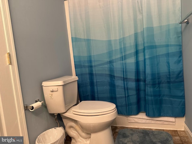 bathroom with shower / bath combo and toilet