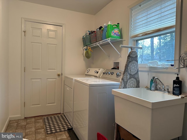 clothes washing area with washer and clothes dryer and sink