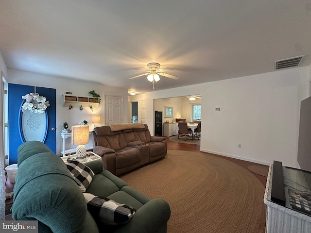 living room featuring ceiling fan with notable chandelier and hardwood / wood-style flooring