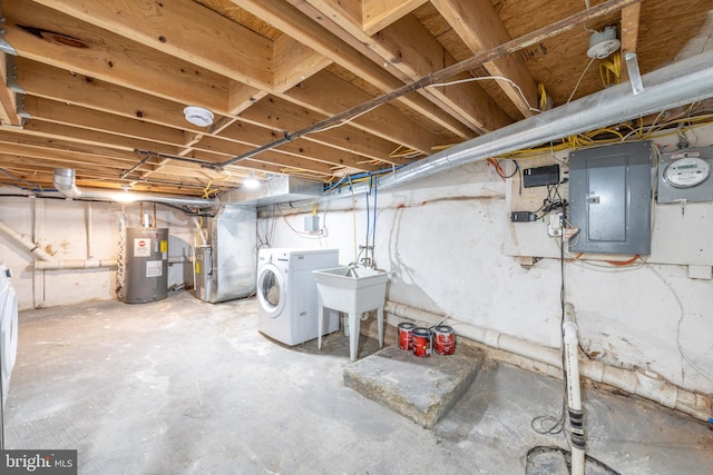 basement featuring washing machine and clothes dryer, electric panel, sink, water heater, and heating unit