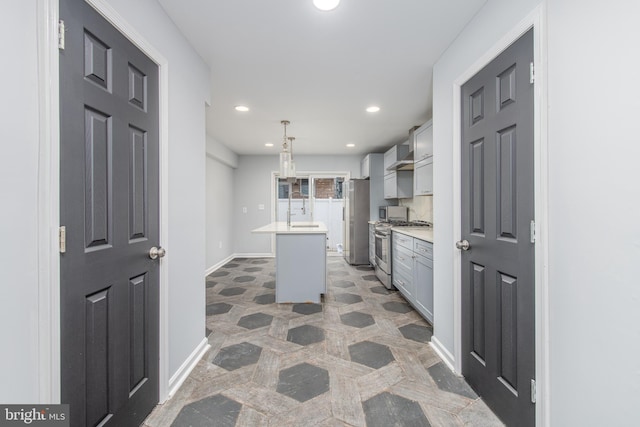 kitchen with a center island, sink, hanging light fixtures, gray cabinets, and stainless steel appliances