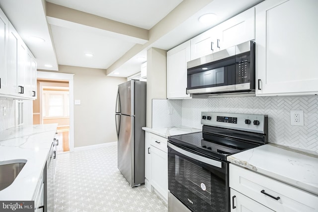 kitchen featuring decorative backsplash, white cabinets, light stone countertops, and appliances with stainless steel finishes