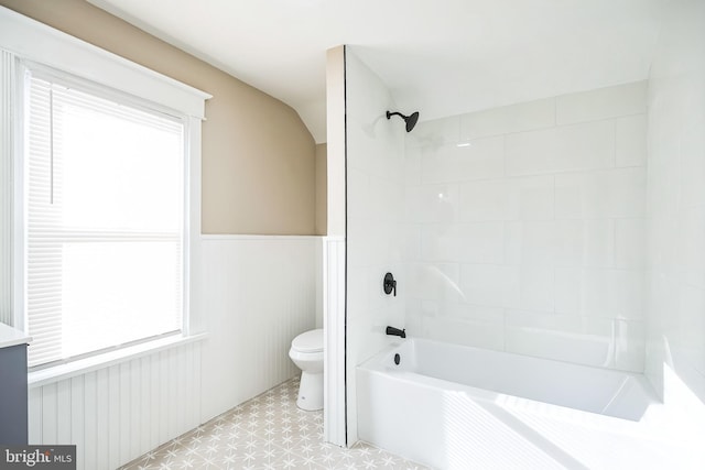 bathroom with toilet, tiled shower / bath, and a healthy amount of sunlight